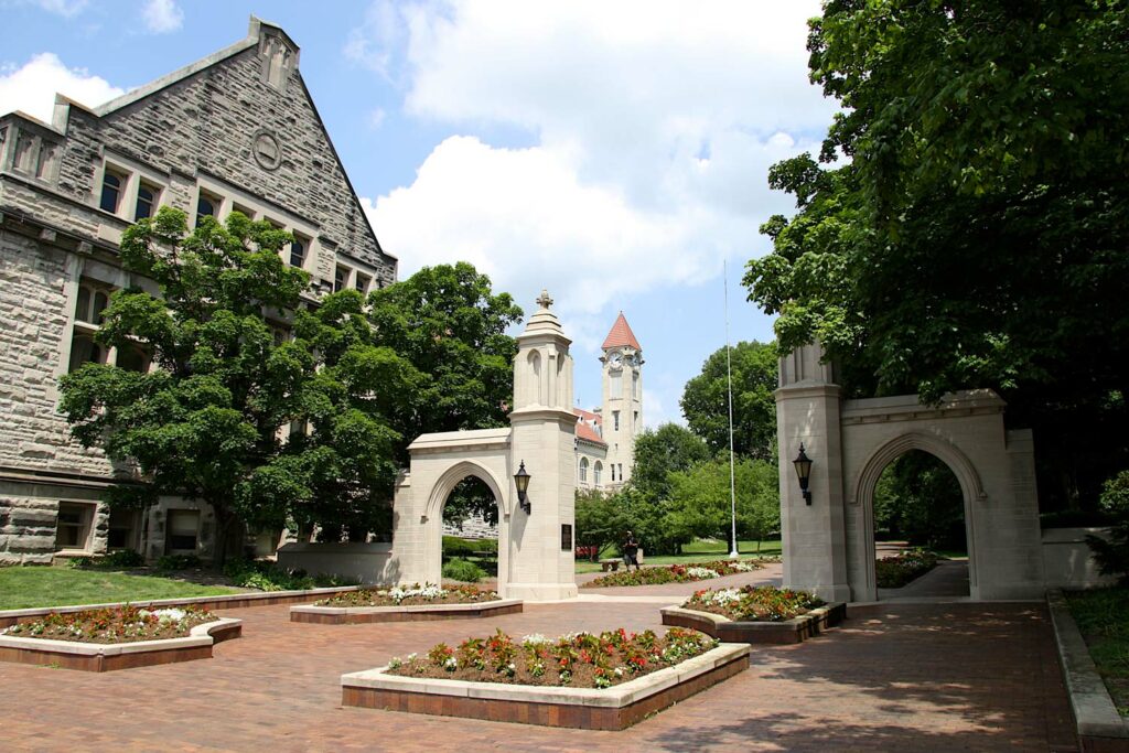 colorful photograph of flowers and the stone Sample Gates with Franklin Hall towering in the background
