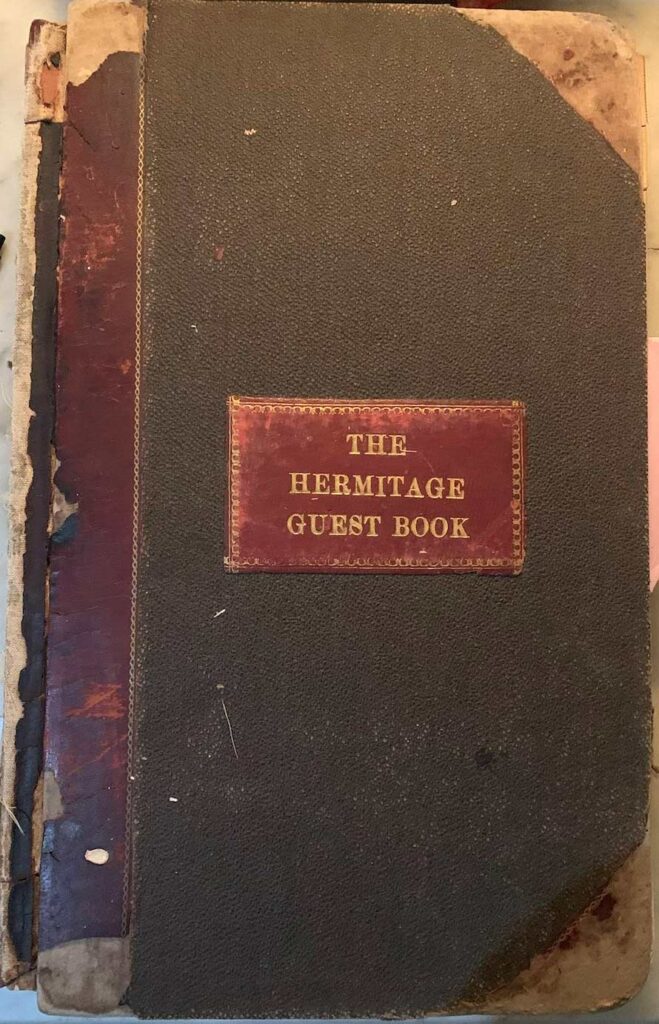 weathered brown book with burgundy label reading "The Hermitage Guest Book"