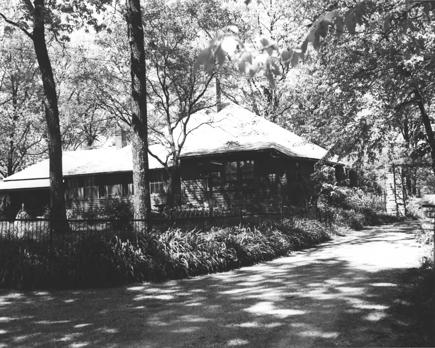 black and white photograph of the wood panelled house with gabled roof