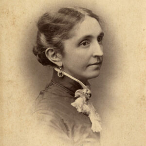 photograph of a young lady with hair in an updo, dangling earrings, and a ruffled white collar