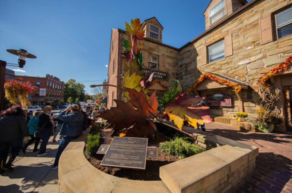 tourists mingle outside a sculpture in downtown Nashville, Indiana