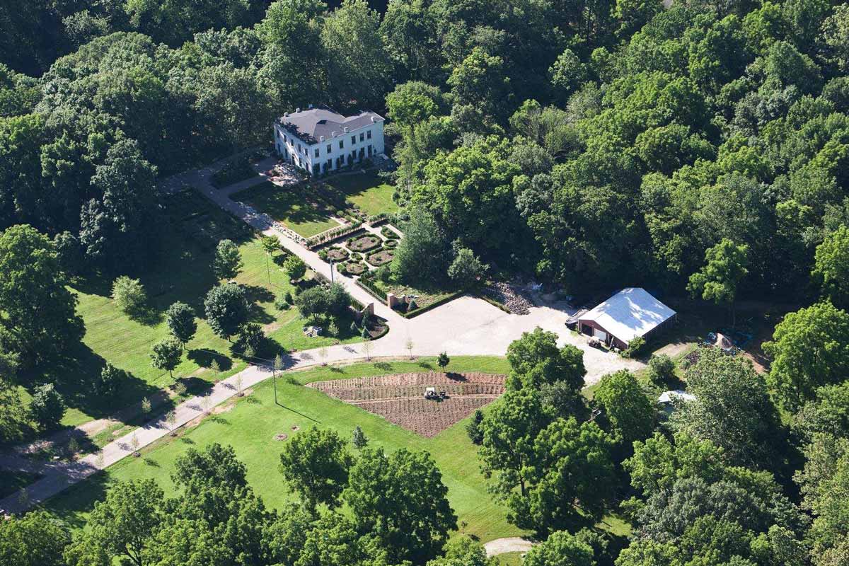 aerial photograph of an estate including gardens and an inn nestled in the woods